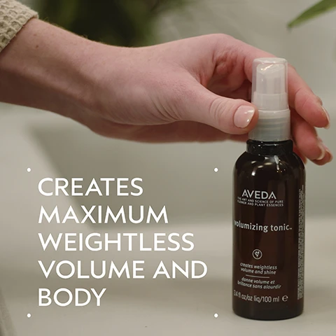 Image 2 - A hand holds a dark brown Aveda Volumizing Tonic spray bottle, with large white text on the left stating CREATES MAXIMUM WEIGHTLESS VOLUME AND BODY, and the bottle itself features text including AVEDA THE ART AND SCIENCE OF PURE FLOWER AND PLANT ESSENCES volumizing tonic creates weightless volume and shine donne volume et brillance sans alourdir 3.4 fl oz/oz liq/100 ml e. Image 3 - A before and after comparison shows a woman with long red hair, on the left her hair appears less voluminous and on the right her hair is full of defined curls; text reads: BEFORE, AFTER, Unwashed Hair, Results with Damage Remedy™ Restructuring Shampoo and Conditioner, Daily Hair Repair, Volumizing Tonic and Light Elements™ Texturizing Cream. Blow dried with diffuser attachment. Image 4 - A circular image of wheat stalks on a dark background is set against a dark green background, with text that reads ALOE & WHEAT HELP BUILD BODY AND ADD SHINE. Image 5 - The image displays a four-step hair care guide on a dark green background, including visuals of a person shampooing, conditioner being squeezed into a hand, a hand holding a hair repair tube, and a hand holding a volumizing tonic spray bottle, alongside the text How To Use, 01 Cleanse Damage Remedy™ Restructuring Shampoo, 02 Condition Damage Remedy™ Conditioner, 03 Treat Damage Remedy™ Daily Hair Repair, 04 Style Volumizing Tonic and Light Elements™ Defining Whip. Image 6 - Numerous clear water droplets of various sizes are scattered across a white background, suggesting freshness or moisture. Image 7 - Three white certification logos are displayed on a background of dark green leaves and a red plant stem, showing 100% VEGAN with a V symbol, Certified B Corporation with a B symbol, and a leaping rabbit symbol for Cruelty Free INTERNATIONAL.