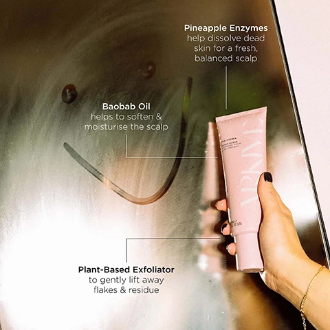 Image 6 - A hand holds a pink tube of Arkive The Crown Scalp Scrub Gommage Pour Cuir Chevelu, 200ml 6.7 FL. OZ. (US) against a reflective surface, with text annotations pointing to different benefits: Pineapple Enzymes help dissolve dead skin for a fresh, balanced scalp; Baobab Oil helps to soften & moisturise the scalp; Plant-Based Exfoliator to gently lift away flakes & residue. Image 7 - A hand holds a pink tube of The Crown Scalp Scrub, with text reading THE CROWN SCALP SCRUB GOMMAGE POUR CUIR CHEVELU BY ADAM REED 180ml e 6.0 FL.OZ, next to usage instructions: HOW TO USE: On a weekly basis, apply a grape-sized amount to hair after shampooing. Focusing on the scalp, gently massage using fingertips. Work through the hair and then rinse thoroughly. TOP TIPS: Use before serums like The Root-ine to maximise absorption and results. Great for post-gym or post-stress - refresh your roots and your mind. Image 8 - The image displays small white flowers with green leaves and a blurred reddish fruit and light-colored object in the background, accompanying text that reads SMELLS LIKE: FUTURE BLOOM A genderful floral fragrance that emulates a sun-soaked summer walk: liberating, luminous and full of potential. HEAD NOTES MANDARIN RHUBARB HEART NOTES JASMINE LILY OF THE VALLEY GROUND NOTES TEA ROSE VANILLA. Image 9 - A light pink tube of ARKIVE The Crown Scalp Scrub is centered on a beige fabric with a repeating yellow and green fan pattern; visible text includes Made Without: Aluminium, Ammonia, Lactose, Latex, Mineral Oil, Parabens, product details The Crown Scalp Scrub Gommage pour Cuir Chevelu by Adam Reed 180 mL e 6.0 FL. OZ. (US), and the certifications Vegan, Certified B Corporation, Made With Recycled Content, Cruelty Free International, and Award Winning.