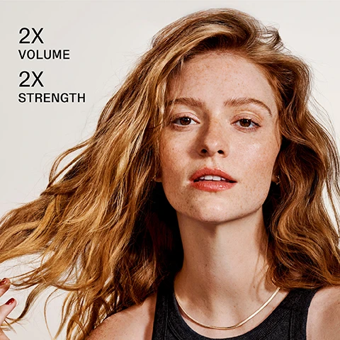 Image 1 - A woman with wavy, shoulder-length reddish-brown hair is looking directly at the camera with a natural makeup look, accompanied by the text 2X VOLUME and 2X STRENGTH on the left side of the image.
Image 2 - Image of two OLAPLEX hair care products, a shampoo labeled OLAPLEX No. 4 Fine Bond Maintenance Shampoo and a conditioner labeled OLAPLEX No. 5 Fine Bond Maintenance Conditioner, with text indicating to Pair With No. 5 FINE For Lasting Volume and features of Volume + Strengthen and Volume + Hydrate.
Image 3 - Image shows a side-by-side comparison of a womans hair before and after treatment; the left side features her with wavy hair that looks dull, while the right side displays her with shinier, smoother hair; text at the bottom notes UNRETOUCHED IMAGES* followed by details about results and product usage.
Image 4 - A woman with long, wavy red hair is holding two bottles of Olaplex hair products and smiling, with text that reads clinically proven to volumize and strengthen fine hair.